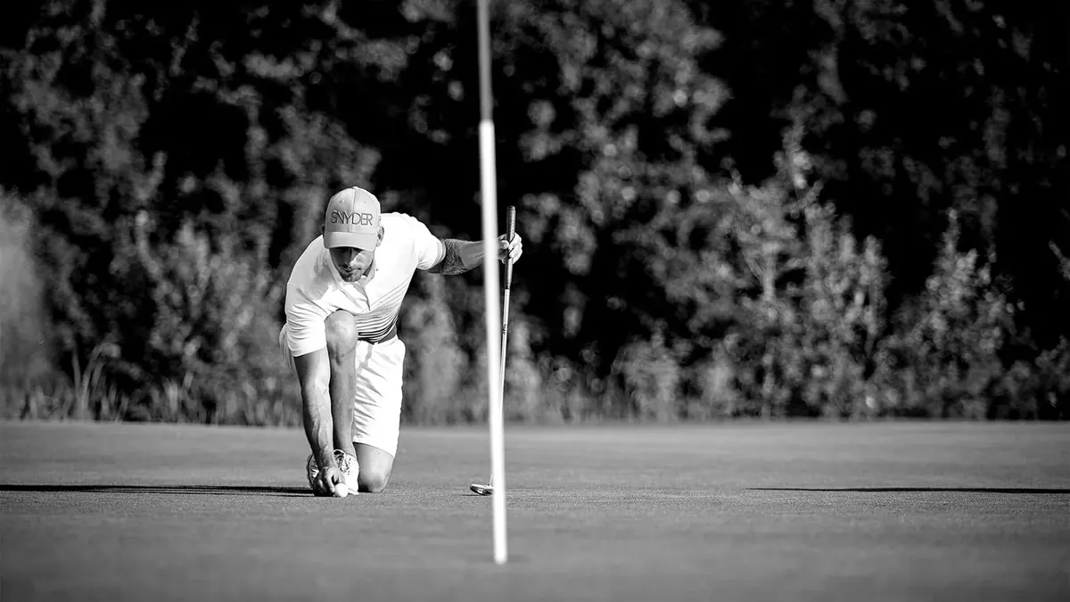 Snyder-Golfspieler beim Platzieren eines Golfballs auf dem Grün